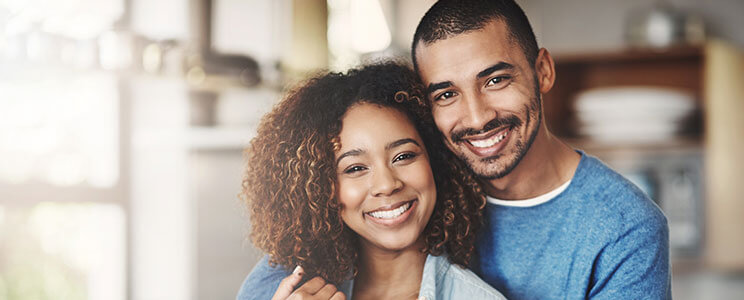 young couple wearing blue shirts, smiling