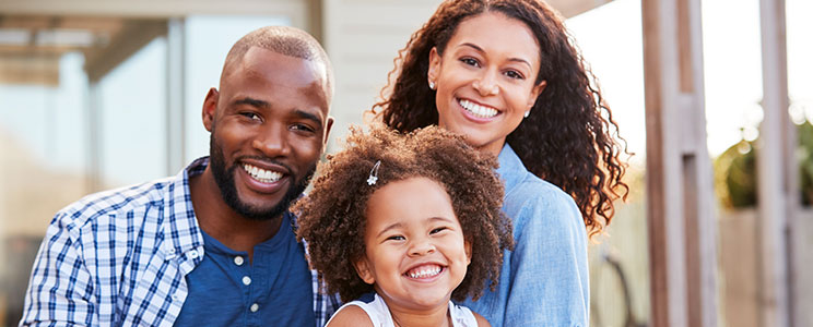 husband, wife and toddler daughter, smiling